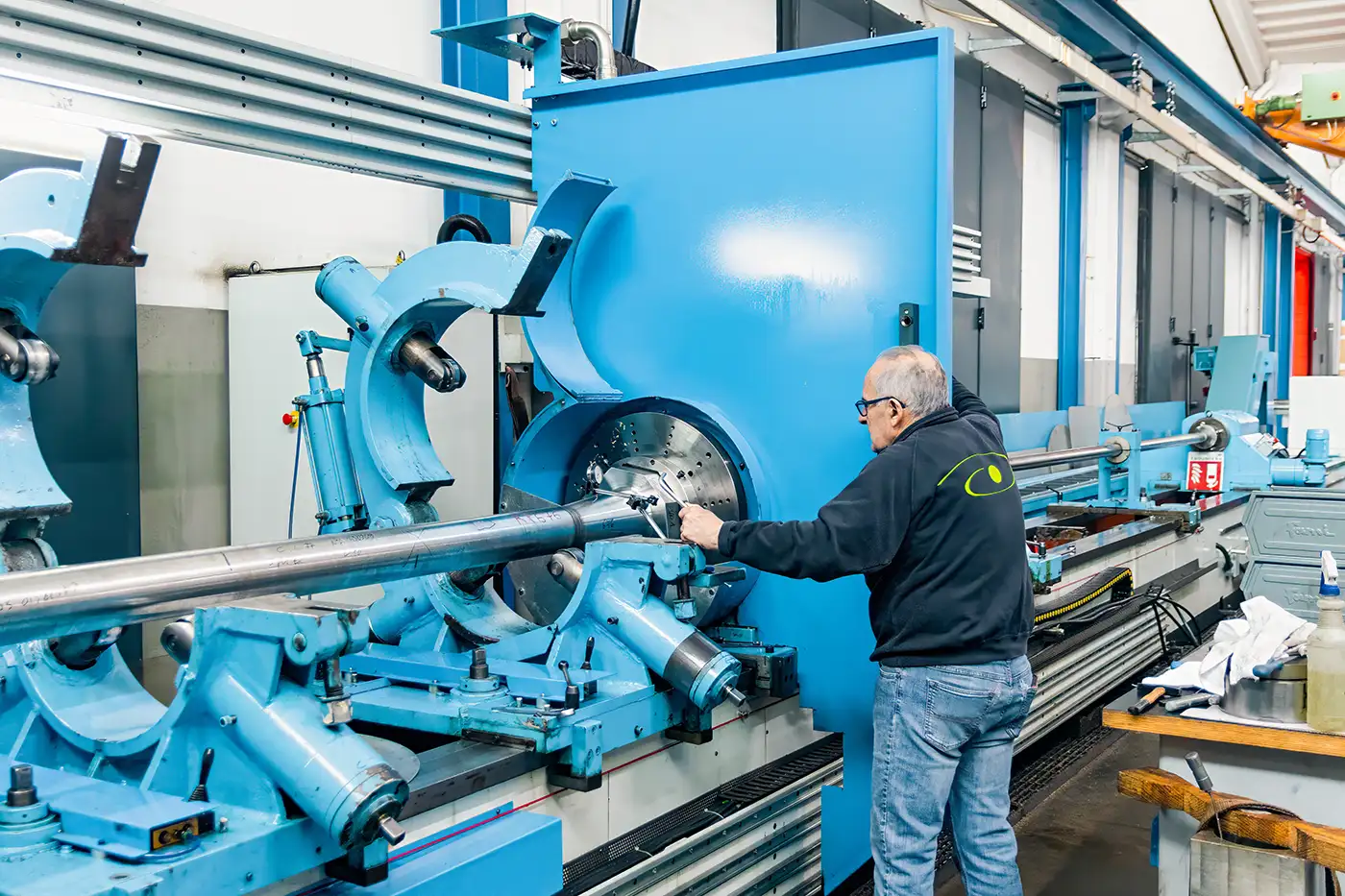 Dipendente di Deep Holes utilizza macchinario azzurro per foratura Dipendente di Deep Holes utilizza macchinario azzurro per foratura