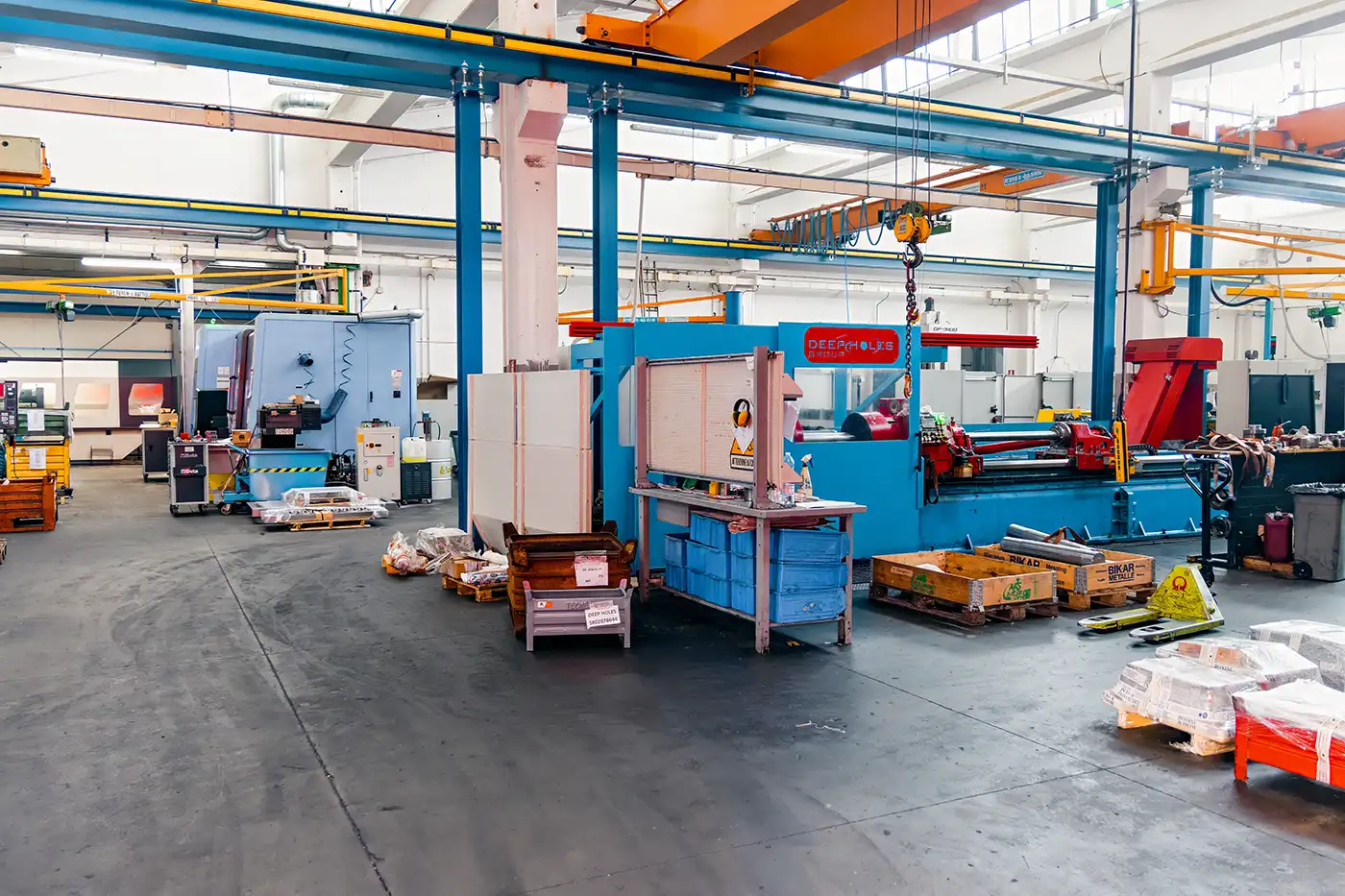 Macchinari azzurri e rossi in azienda Deep Holes a Modena