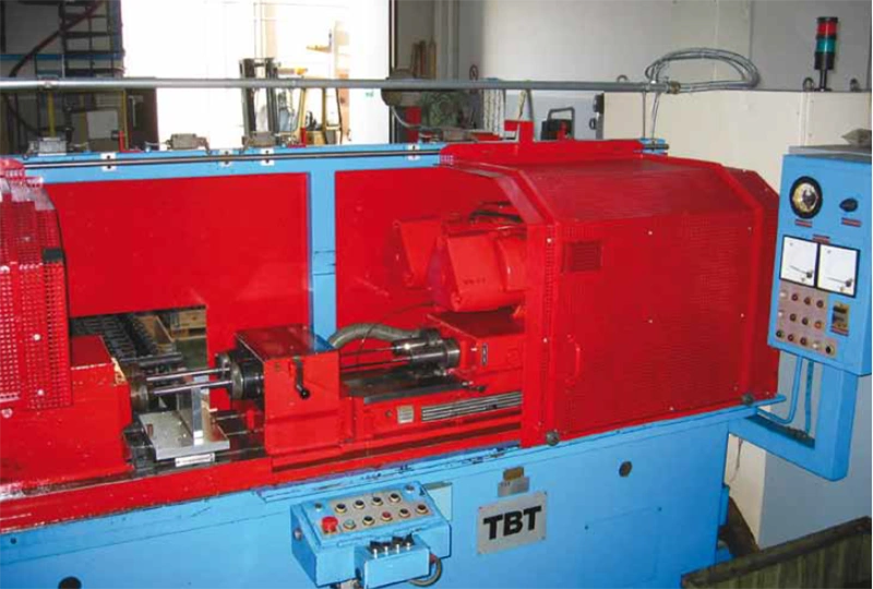 Macchinario rosso e azzurro per la foratura in asse